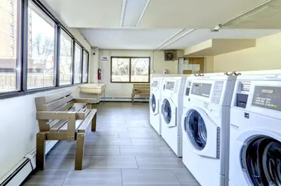 a laundry room with washing machines and a bench at Spacious Top Floor at Stampede w Free Parking and AC in Calgary