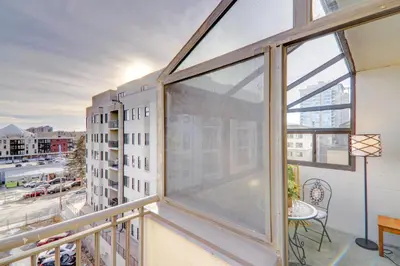 a balcony with a large window with a view of a city at Spacious Top Floor at Stampede w Free Parking and AC in Calgary