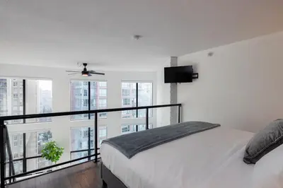 a bedroom with a bed and a large window at Loft in Entertainment District with FREE underground Parking in Vancouver