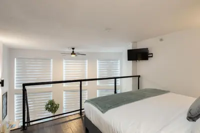 a bedroom with a bed and a balcony with windows at Loft in Entertainment District with FREE underground Parking in Vancouver