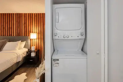 a room with a washer and dryer next to a bed at Loft in Entertainment District with FREE underground Parking in Vancouver