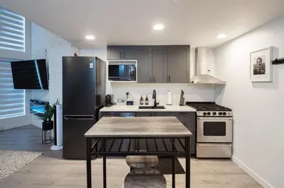 a kitchen with a refrigerator and a table in it at Loft in Entertainment District with FREE underground Parking in Vancouver