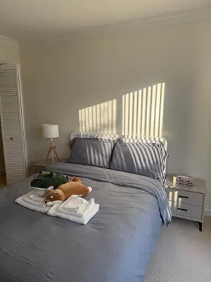 a bed with a stuffed animal and towels on it at The Ester House in Vancouver