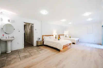 a bedroom with two beds and a sink in it at The Ester House in Vancouver