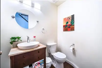 a bathroom with a sink and a toilet and a mirror at The Ester House in Vancouver