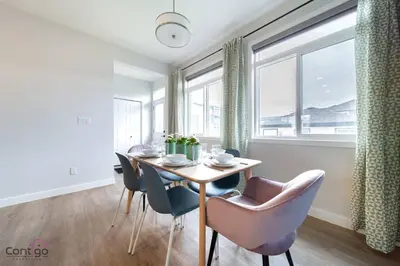 a dining room with a table and chairs and a window at The Nest, 3BR, AC, Near YEG Airport, King Bed! in Edmonton