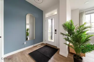 a hallway with blue walls and a potted plant at The Nest, 3BR, AC, Near YEG Airport, King Bed! in Edmonton