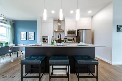 a kitchen with a counter with stools in it at The Nest, 3BR, AC, Near YEG Airport, King Bed! in Edmonton