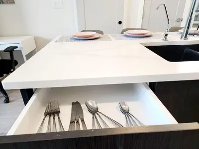 a drawer with spoons and plates on a table at Luxury Cozy Basement Suite in Leduc