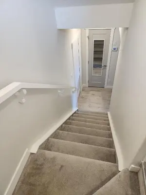 a staircase in a white room with a stair case at Luxury Cozy Basement Suite in Leduc