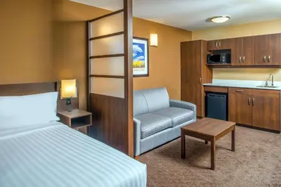 a hotel room with a bed and a kitchen at Microtel Inn & Suites by Wyndham Red Deer in Red Deer