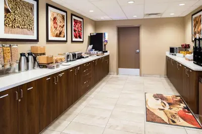 a kitchen with wooden cabinets and a counter at Microtel Inn & Suites by Wyndham Red Deer in Red Deer