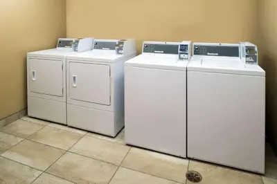 three washing machines are sitting in a room at Microtel Inn & Suites by Wyndham Red Deer in Red Deer