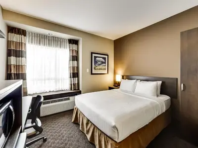 a hotel room with a bed and a window at Microtel Inn & Suites by Wyndham Red Deer in Red Deer