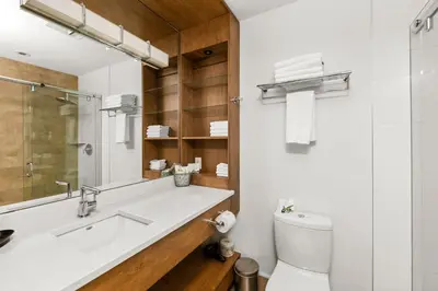 a bathroom with a sink and a toilet and a mirror at Sproat Lake Landing Resort in Port Alberni