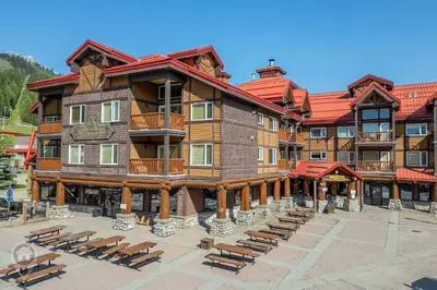 a large building with benches in front of it at Cornerstone Lodge by StayIn in Fernie