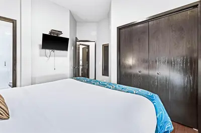 a bedroom with a white bed and a wooden cabinet at Mountain Getaway in Canmore - Sleeps 6 - Pool & Hottub in Canmore