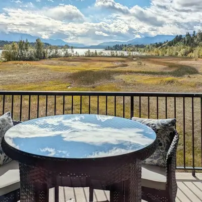 a table on a balcony with a view of a field at Lake View From Every Window! in Invermere