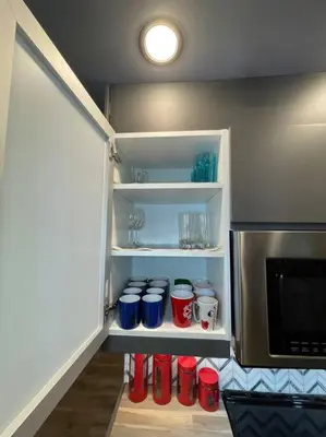 a refrigerator with red and blue cups and a microwave at Comfortable and Beautiful Brand-New Suite BSMT-Two Bedroom, Two Washrooms in Calgary
