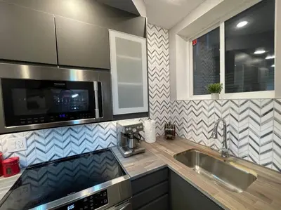 a kitchen with a sink and a microwave at Comfortable and Beautiful Brand-New Suite BSMT-Two Bedroom, Two Washrooms in Calgary