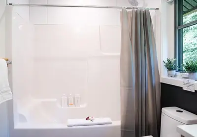 a white bathroom with a shower and a toilet at The Cedar Suite - Secluded Mountain Retreat with Forest Views and Hot Tub in Revelstoke