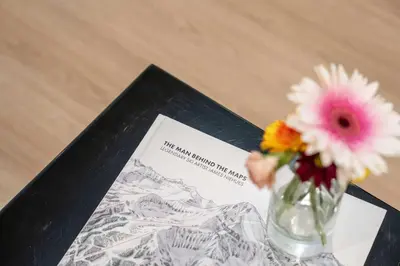 a vase of flowers sitting on top of a picture at The Cedar Suite - Secluded Mountain Retreat with Forest Views and Hot Tub in Revelstoke