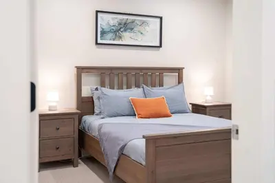 a bedroom with a bed with an orange pillow on it at The Cedar Suite - Secluded Mountain Retreat with Forest Views and Hot Tub in Revelstoke