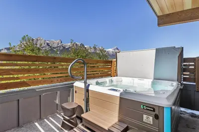 a hot tub on a balcony with a view at Sisters Summit Villa by WeekAway Vacations in Canmore