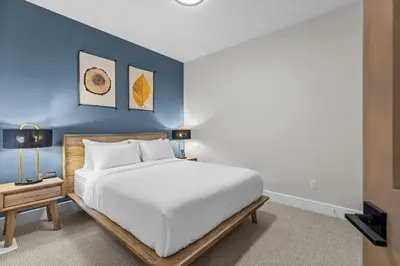 a bedroom with a white bed and a blue wall at Sisters Summit Villa by WeekAway Vacations in Canmore