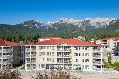 a large apartment building with mountains in the background at Mountain View Villas with Fairmont Creek Vacation Rentals in Fairmont Hot Springs