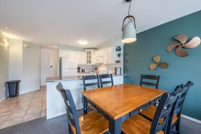 a dining room and kitchen with a wooden table and chairs at Mountain View Villas with Fairmont Creek Vacation Rentals in Fairmont Hot Springs