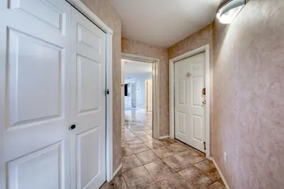 a hallway with white doors and a tile floor at Mountain View Villas with Fairmont Creek Vacation Rentals in Fairmont Hot Springs