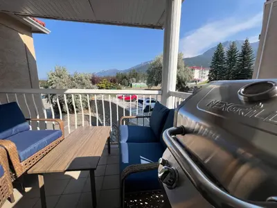 a balcony with a table and chairs and a view at Mountain View Villas with Fairmont Creek Vacation Rentals in Fairmont Hot Springs