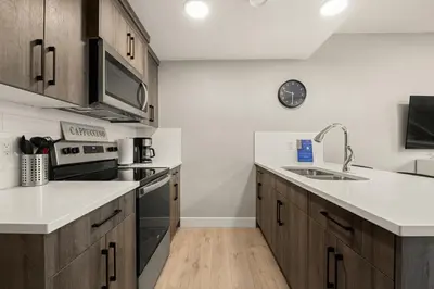 a kitchen with wooden cabinets and a sink at Heart of Hillhurst 1BR Home ! in Calgary