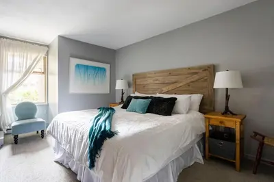 a bedroom with a bed and a blue chair at Whistler Gleneagle 27 in Whistler