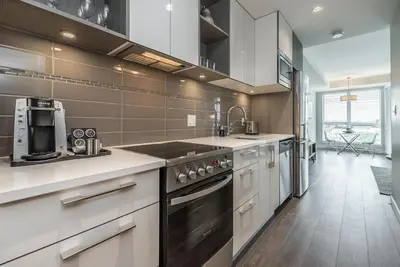 a kitchen with white cabinets and a stove top oven at Be The Lively Cityzen In Cityzen in Victoria