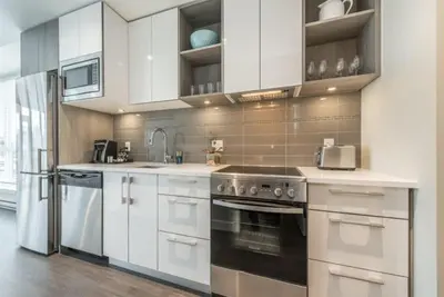 a kitchen with white cabinets and stainless steel appliances at Be The Civilised Cityzen In Cityzen in Victoria