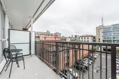 a balcony with a table and chairs and a view of a city at Be The Civilised Cityzen In Cityzen in Victoria