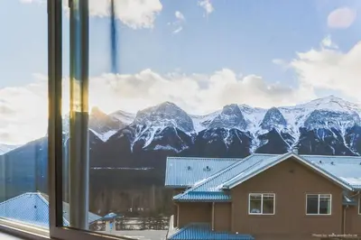 a view of a snowy mountain range from a window at Entire Lovely Townhouse Mountain View! in Canmore