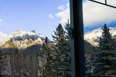 a view of a snow covered mountain from a window at Entire Lovely Townhouse Mountain View! in Canmore