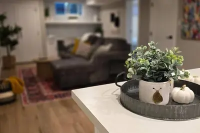 a living room with a table with a plant and pumpkins at Boho Bliss - Just steps away from the Hospital in Prince George