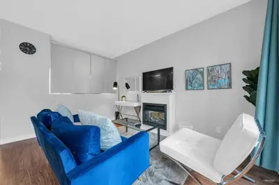 a living room with a blue couch and a fireplace at Lovely 2-Bedrooms Downtown suite Free Parking in Vancouver