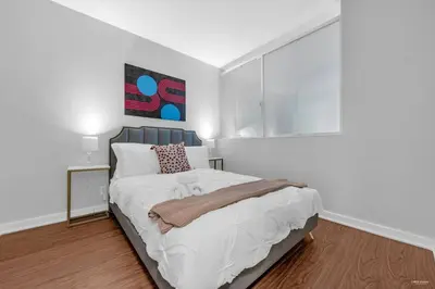 a bedroom with a bed and a painting on the wall at Lovely 2-Bedrooms Downtown suite Free Parking in Vancouver