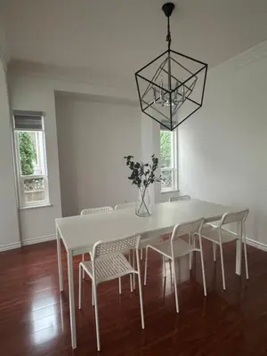 a white dining room table with chairs and a vase with flowers at Spacious Getaway in Surrey in Surrey
