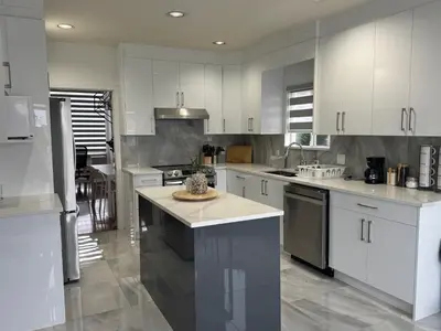 a kitchen with white cabinets and a island in it at Spacious Getaway in Surrey in Surrey