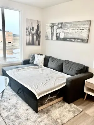 a bed in a living room with a couch at Humble Living in Edmonton