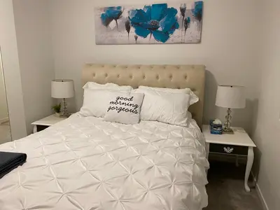 a bed with a white comforter and a pillow on it at Humble Living in Edmonton