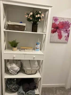 a white shelf with a vase of flowers in it at Humble Living in Edmonton