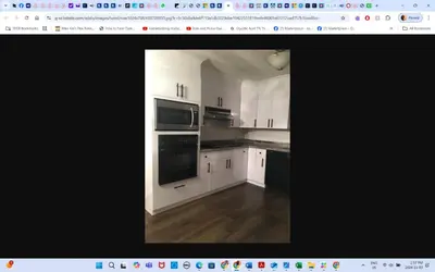 a kitchen with white cabinets and black appliances at Room # 3 Sleep 4 Arrangement in Edmonton