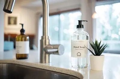 a bottle of hand soap sitting next to a sink at Blueberry Hill Estates 3180 by Outpost Whistler in Whistler